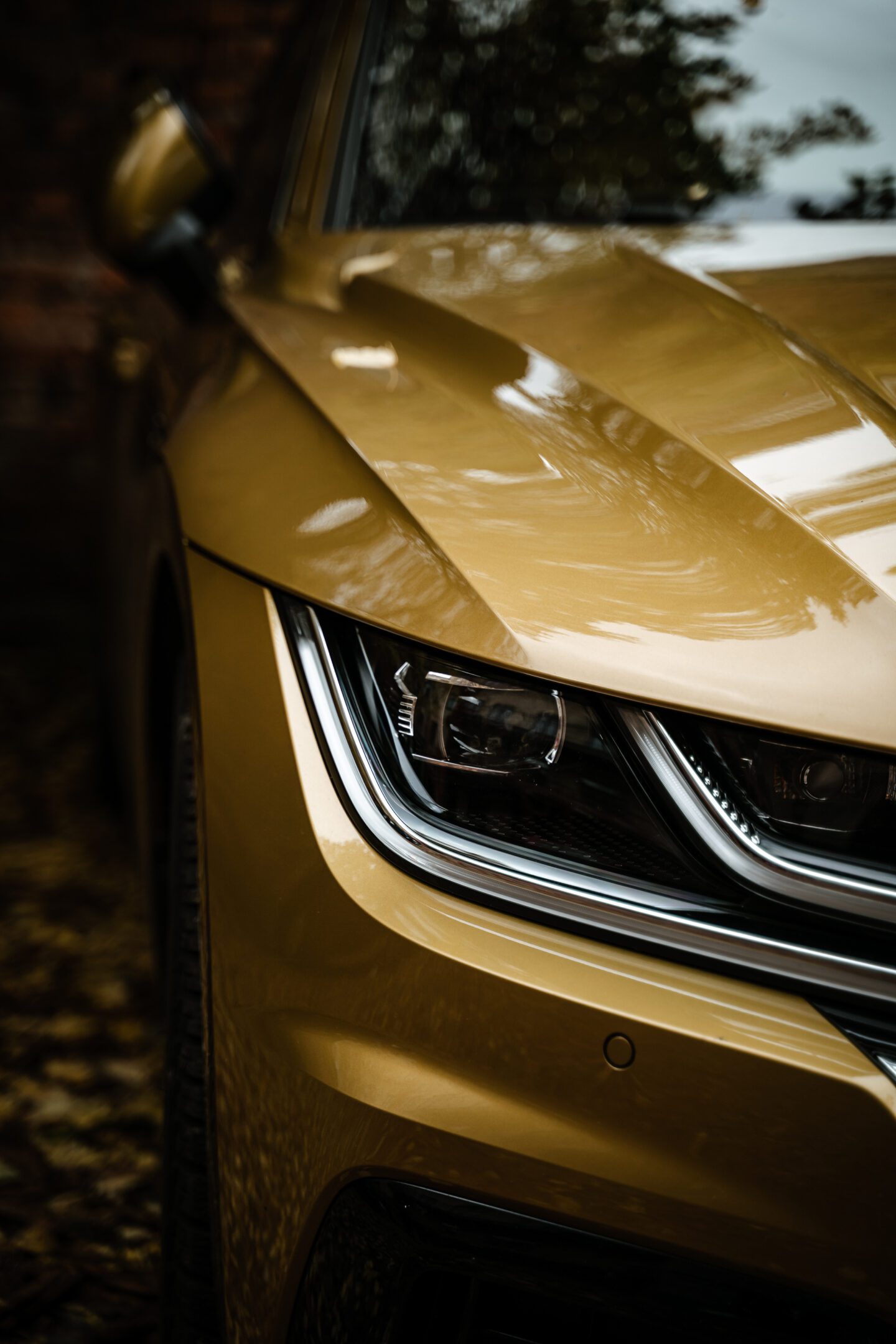 A vertical shot of the headlight of the matte gold car