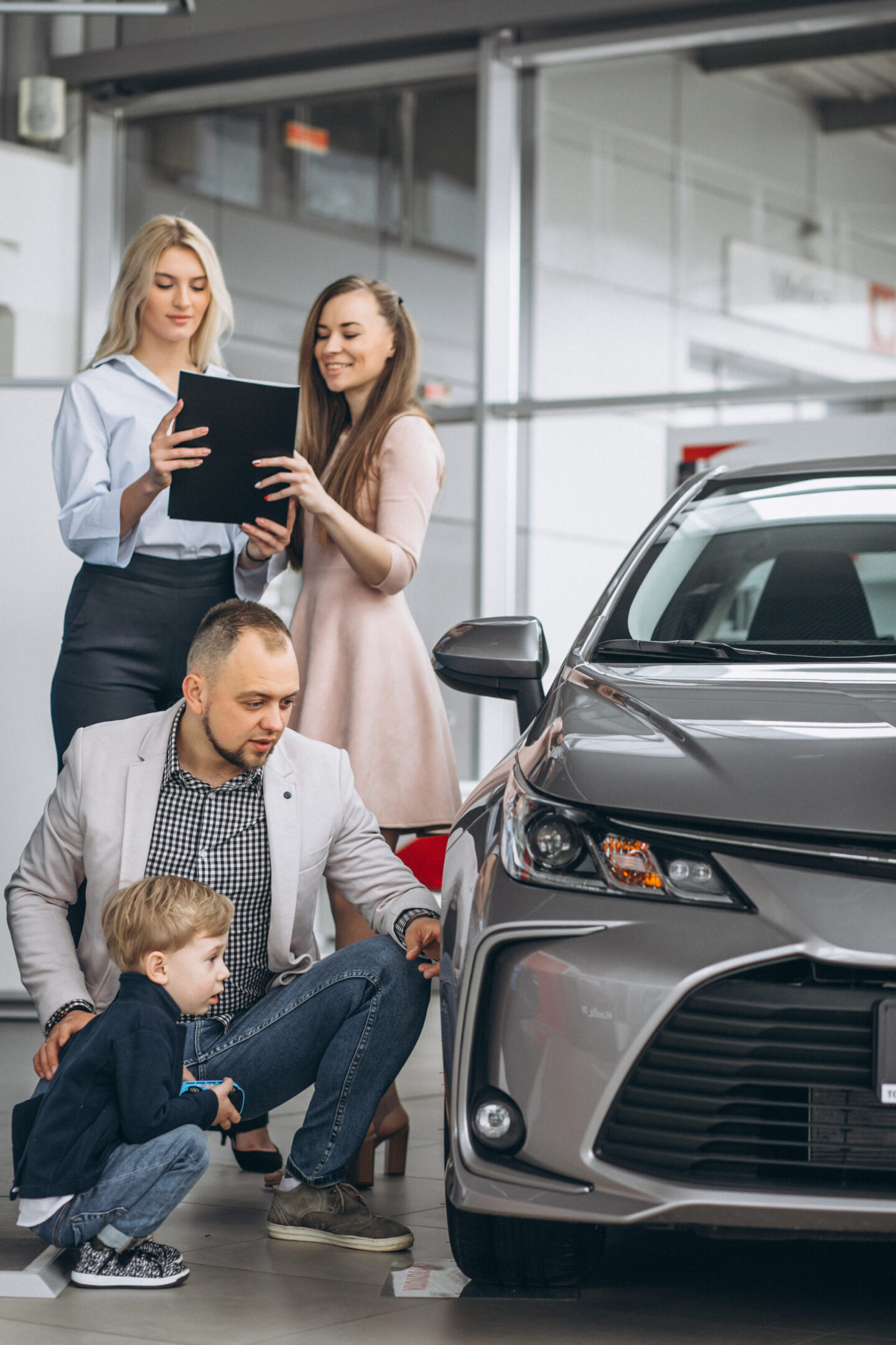 Family with son choosing a car in a car showroom